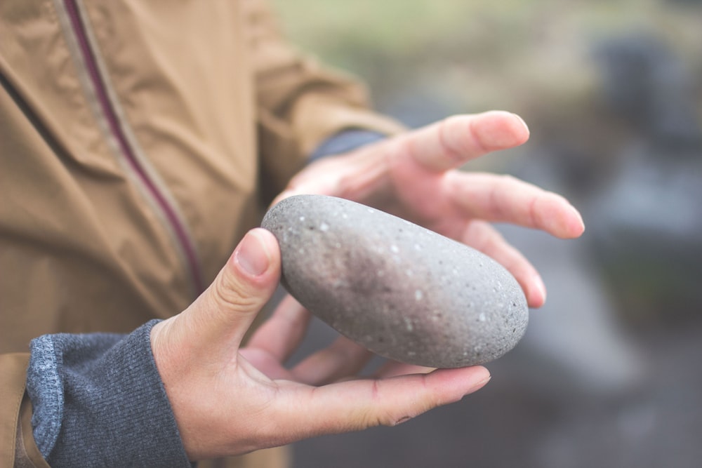 person holding river rock