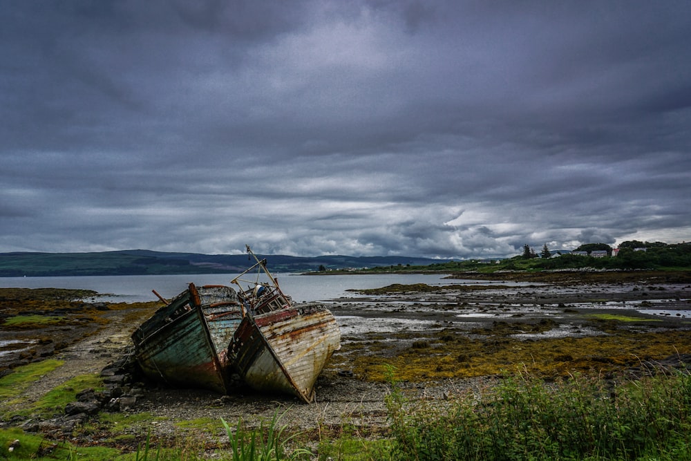 Fotografia de paisagem de dois barcos perto do corpo de água