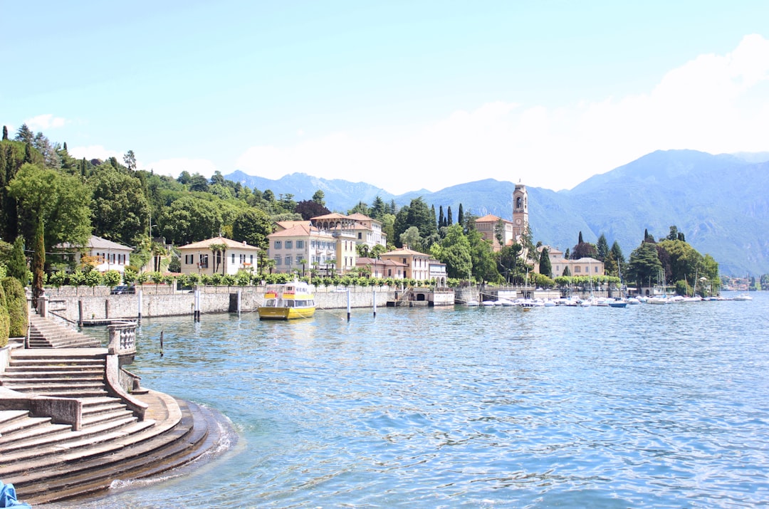 yellow boat docked near building, Mediterranean waterfront- Lake Como