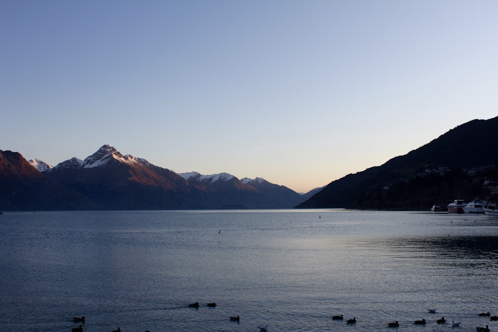 Photographie d’un plan d’eau calme près des montagnes pendant la journée