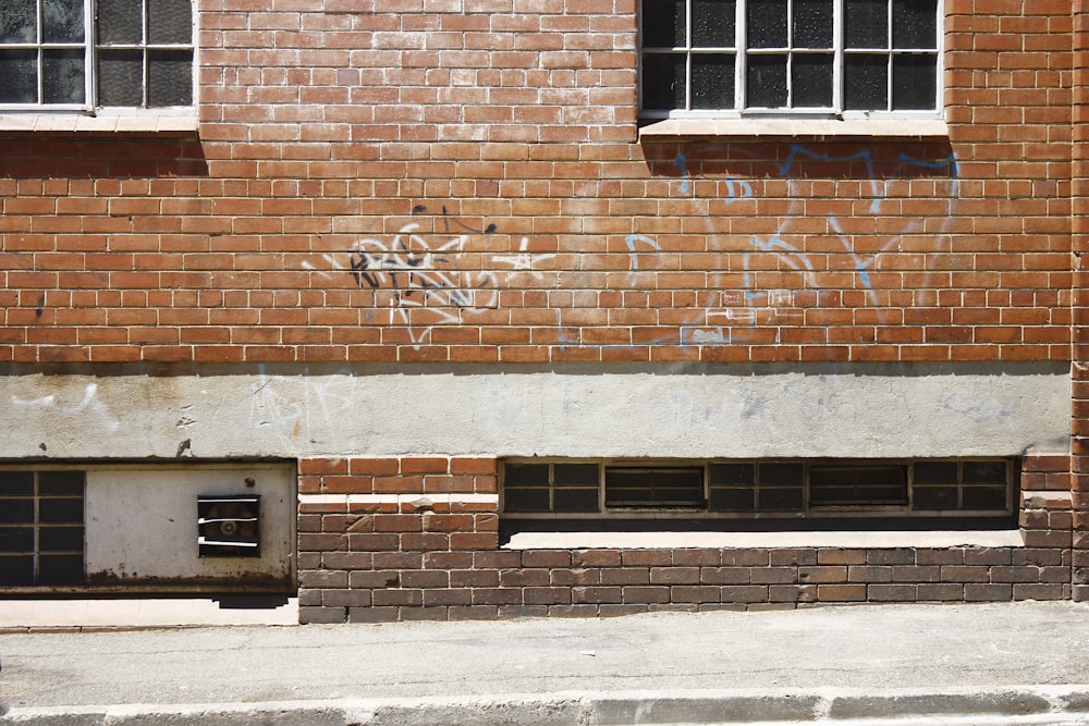 white spray paint texts printed on brown brick wall