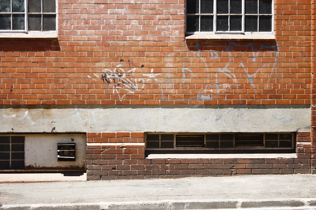 white spray paint texts printed on brown brick wall