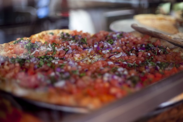 Close-up of a delicious pizza topped with colorful Indian spices and fresh ingredients.