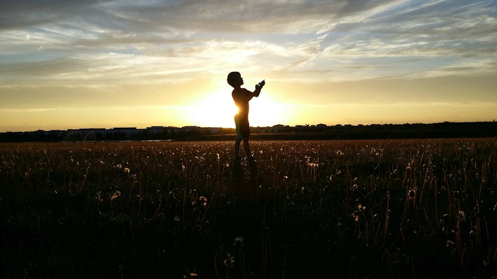 silhouette photo of a person lifting his hand