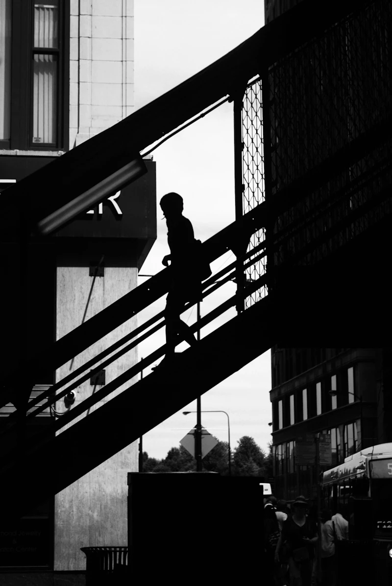 Silhouetted figure descending a staircase, black and white