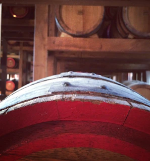 Close-up of oak barrels aging whiskey in a dimly lit cellar