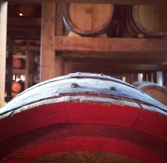 Close-up of oak barrels aging whiskey in a dimly lit cellar