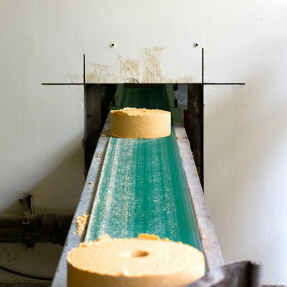two cylindrical brown block on conveyor belt