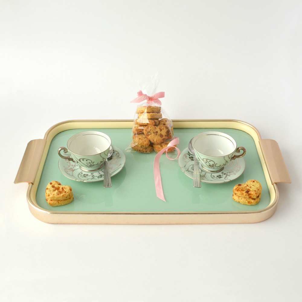 rectangular beige and green tea set and packed cookies