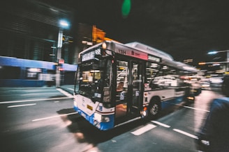 A vibrant city bus making its way through busy urban streets during rush hour.