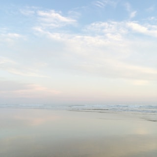 A tranquil beach scene with gentle waves and a pastel sky.