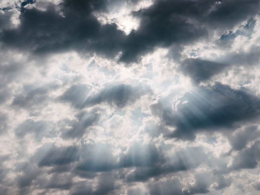 Photographie de nuages blancs avec réfection du soleil vers le bas