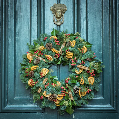 A festive floral wreath with bright orange and yellow blossoms hanging on a door.