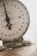 An old mechanical weighing scale with a rustic appearance. The dial has numbers from 0 to 23 and the text 'American Family Scale' printed on it. The base shows signs of wear with chipped paint and a greenish hue.