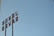 A metal sign with the letters oriented vertically against a clear blue sky. The letters appear to be arranged in an industrial style, attached to tall poles, suggesting a retro or vintage aesthetic.