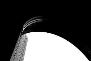 Black and white photograph capturing a dramatic shadow play on urban architecture