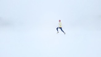 person wearing yellow jacket and black pants