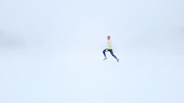 person wearing yellow jacket and black pants