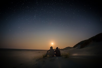 silhouette of two person sitting during golden hour friend zoom background