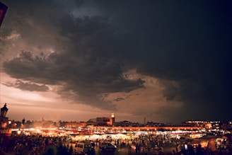 A moody sky over a bustling Thai street market at dusk.