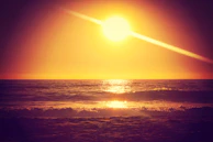 Sunset over the coastline of Vigo, with soft orange hues reflecting on the water.