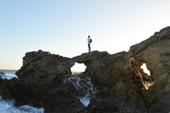 man standing on brown rock formations in Leo Carrillo State Park United States