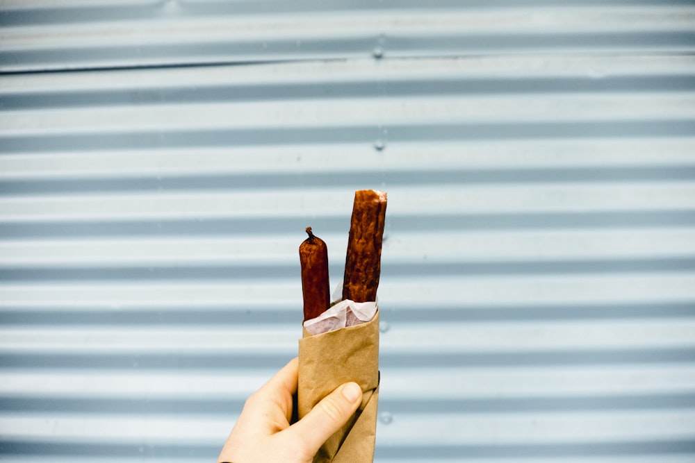 person carrying hotdog sandwich