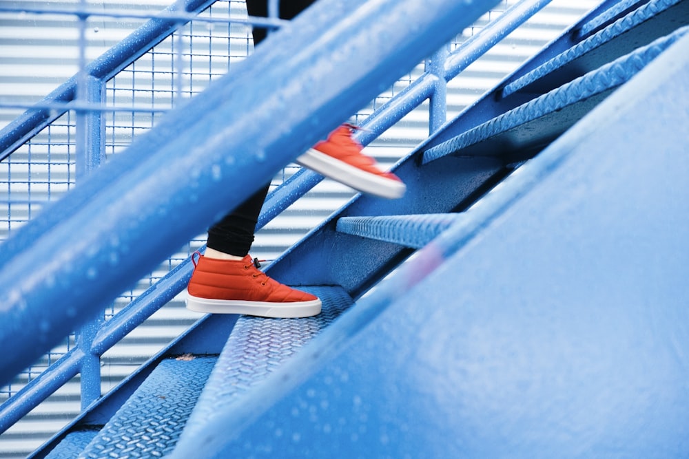 Person, die auf eine blaue Treppe tritt