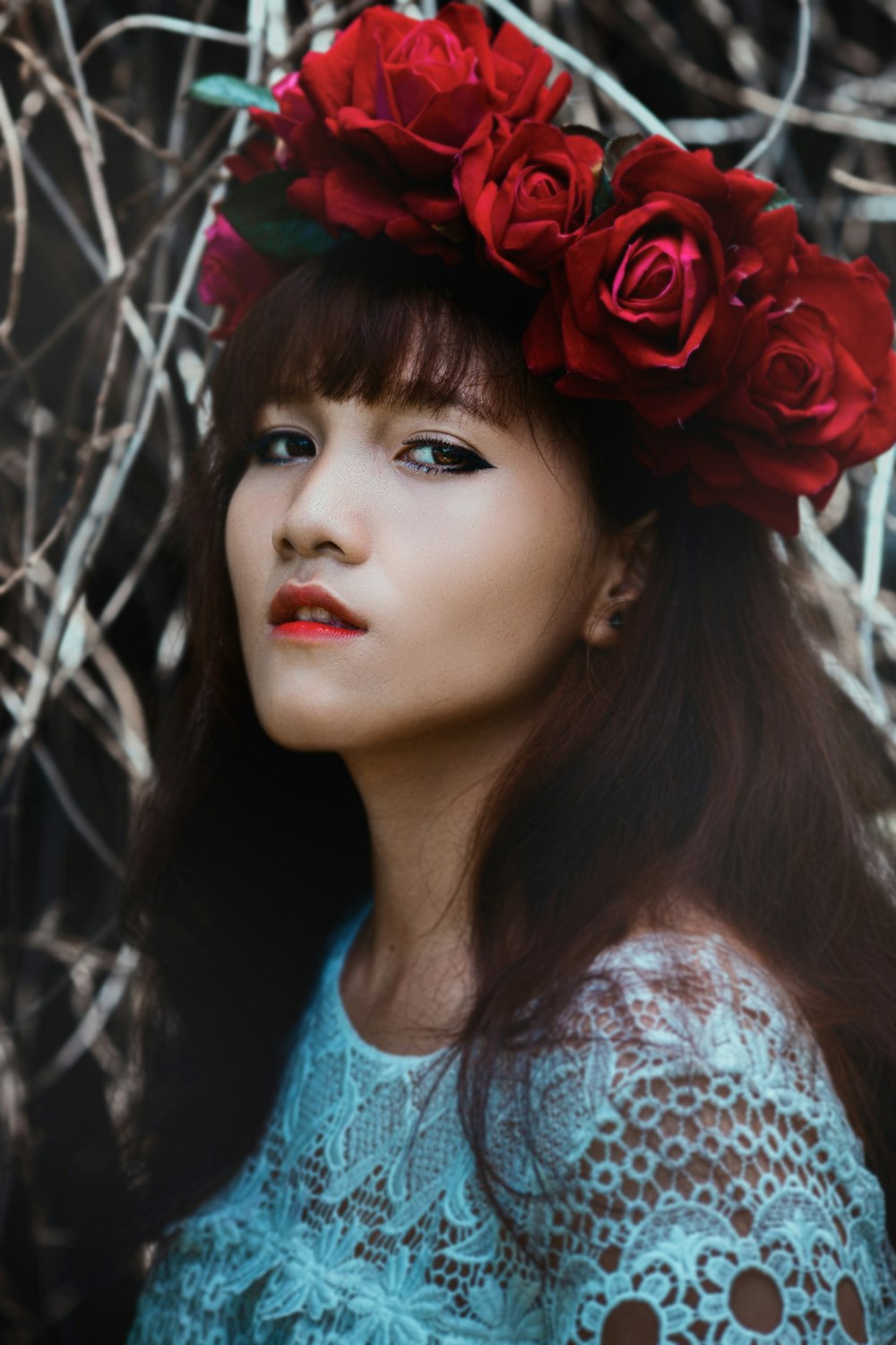 femme portant une couronne de fleurs rouges