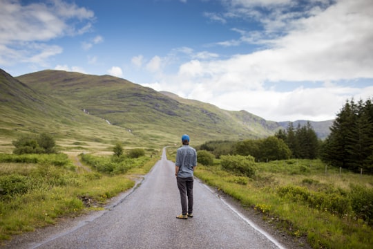 man standing on concrete road in Isle of Mull United Kingdom