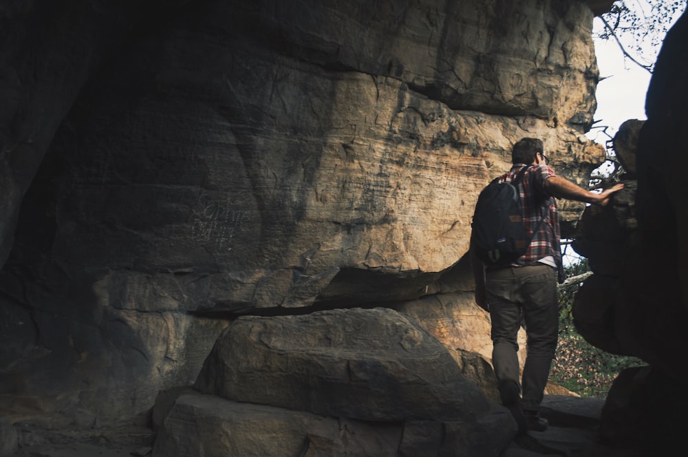 man with backpack at the cave