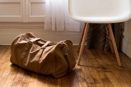 A spacious duffel bag packed and ready beside a cozy airport lounge window.