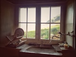 A rustic kitchen with open shelving and farmhouse sink, bathed in natural light.