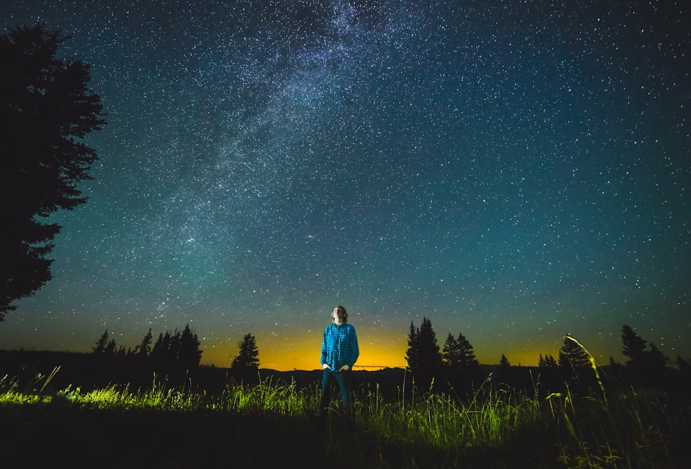 man standing on lawn during nighttime