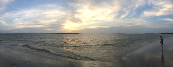 A serene traveler gazing over a quiet Thai beach at sunset, embodying calm and thoughtful exploration.