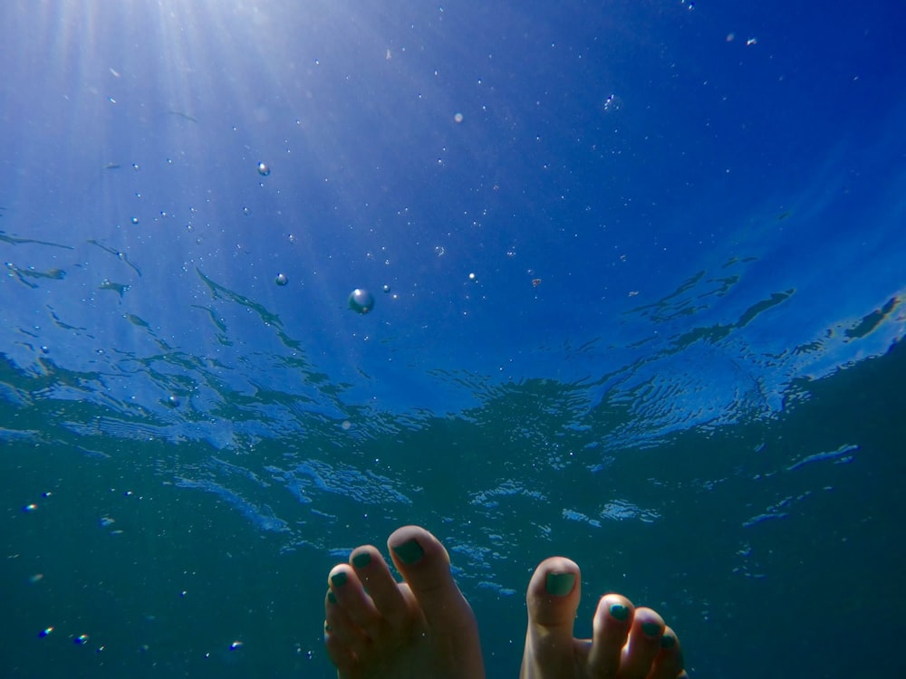 pés humanos no corpo de água durante o dia