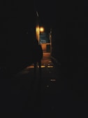 A shadowy figure standing silently in a dark alley.