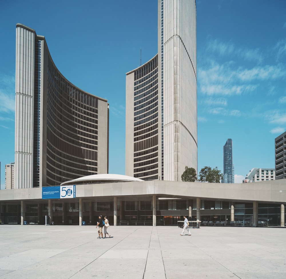 people walking in front of gray concrete building