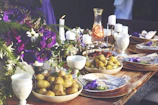 A beautifully set catering table featuring a variety of dishes under warm lighting.