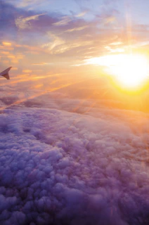 Heavy jet soaring above the clouds during a stunning sunset flight