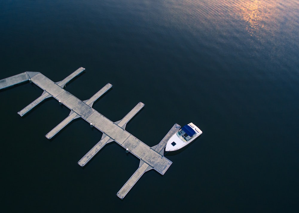 Yacht bianco vicino al molo sullo specchio d'acqua