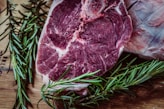 raw meat and green leaf plant on brown surface