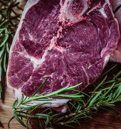 raw meat and green leaf plant on brown surface