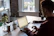 Happy woman using a laptop in a cozy home setting with natural light.
