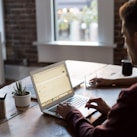 man operating laptop on top of table