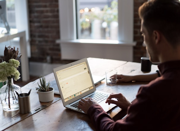 man operating laptop on top of table