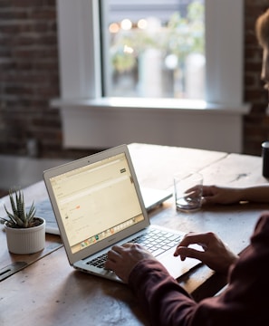 man operating laptop on top of table