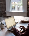 man operating laptop on top of table