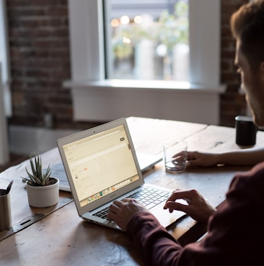 man operating laptop on top of table