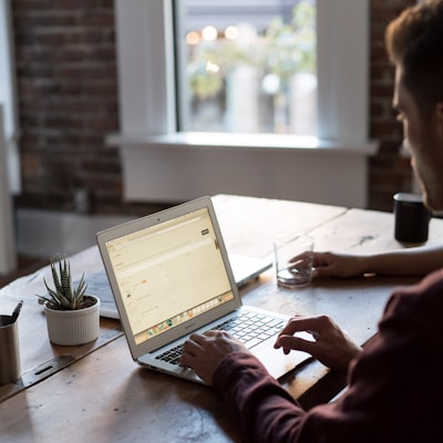 man operating laptop on top of table